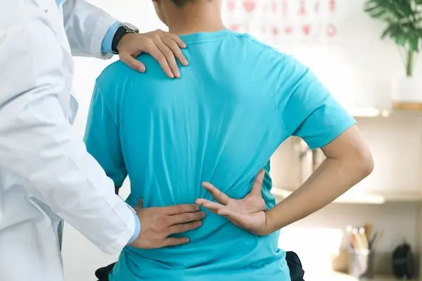 doctor assisting patient who has chronic back pain