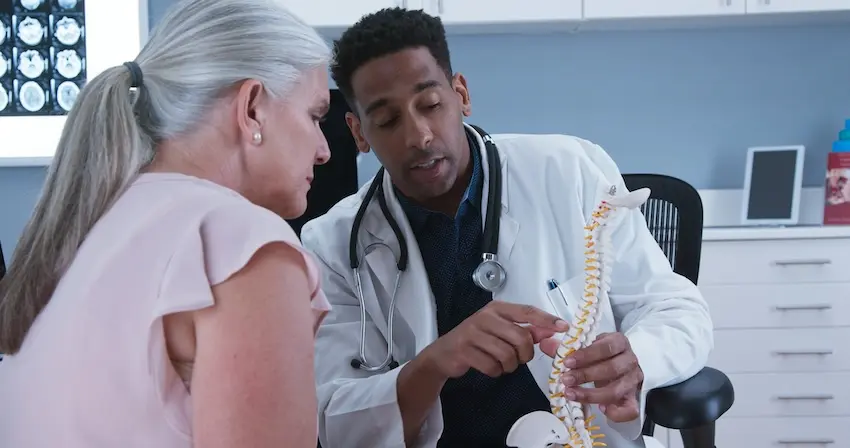 VeriSpine physician evaluating functional capacity and discussing treatment options with injured patient
