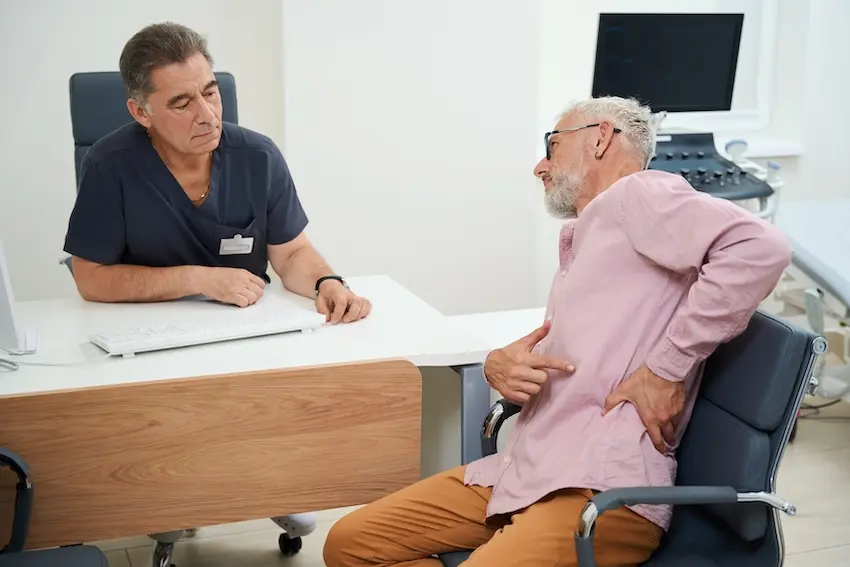 Doctor discussing modern pain management techniques with patient in medical office
